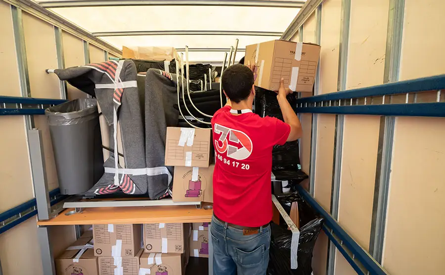 Déménageur chargeant un camion avec des meubles.